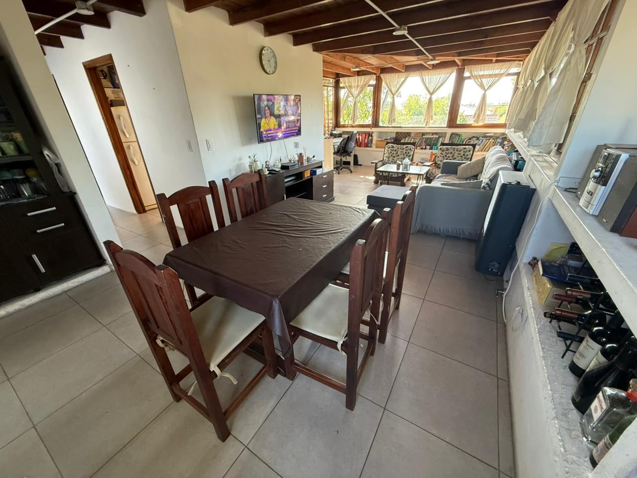 Sector comedor con mesa de madera para seis y ventanal corrido