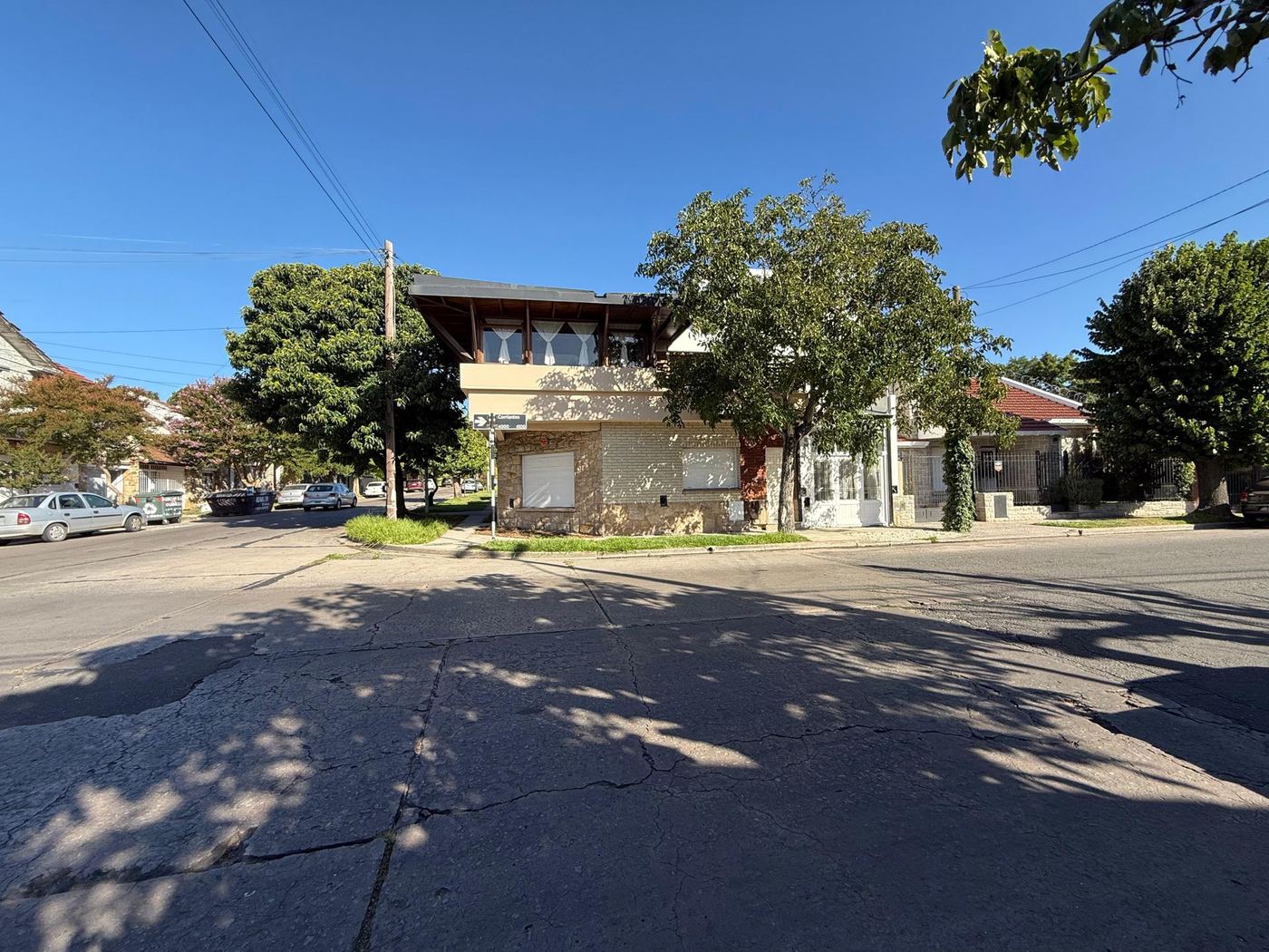Vista de la cuadra desde la esquina, con árboles y casas bajas
